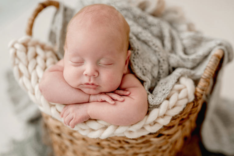 newborn baby in basket with blanket