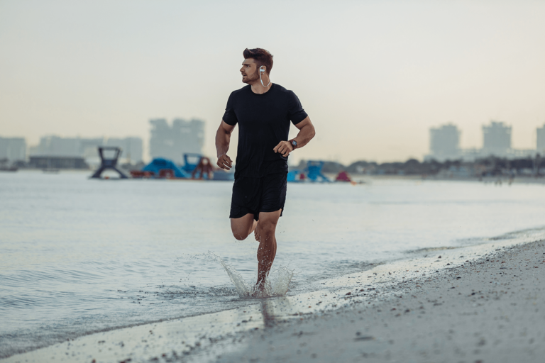 man running on the beach at sunrise