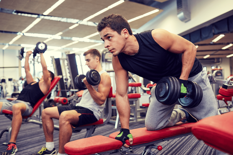 three men at gym lifting free weights