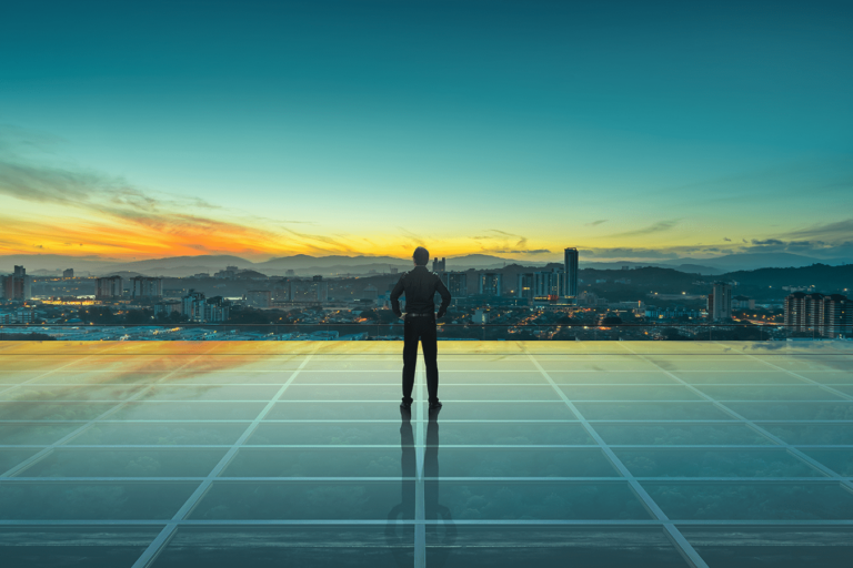 man standing on solar panels looking out on city