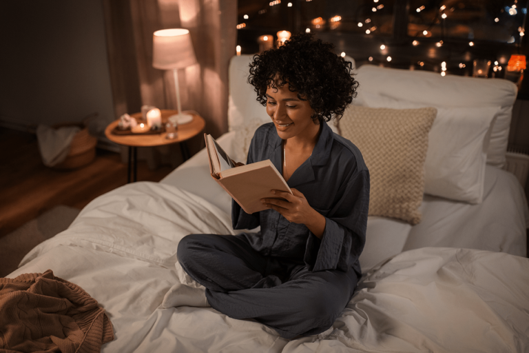 woman reading a book on a cozy bed